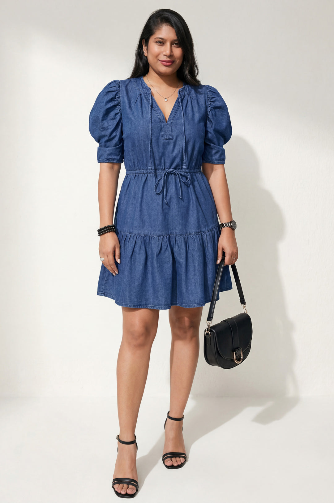 Errabelly blue denim mini dress with puff sleeves, drawstring waist, and tiered hem. V-neck with tie detail.