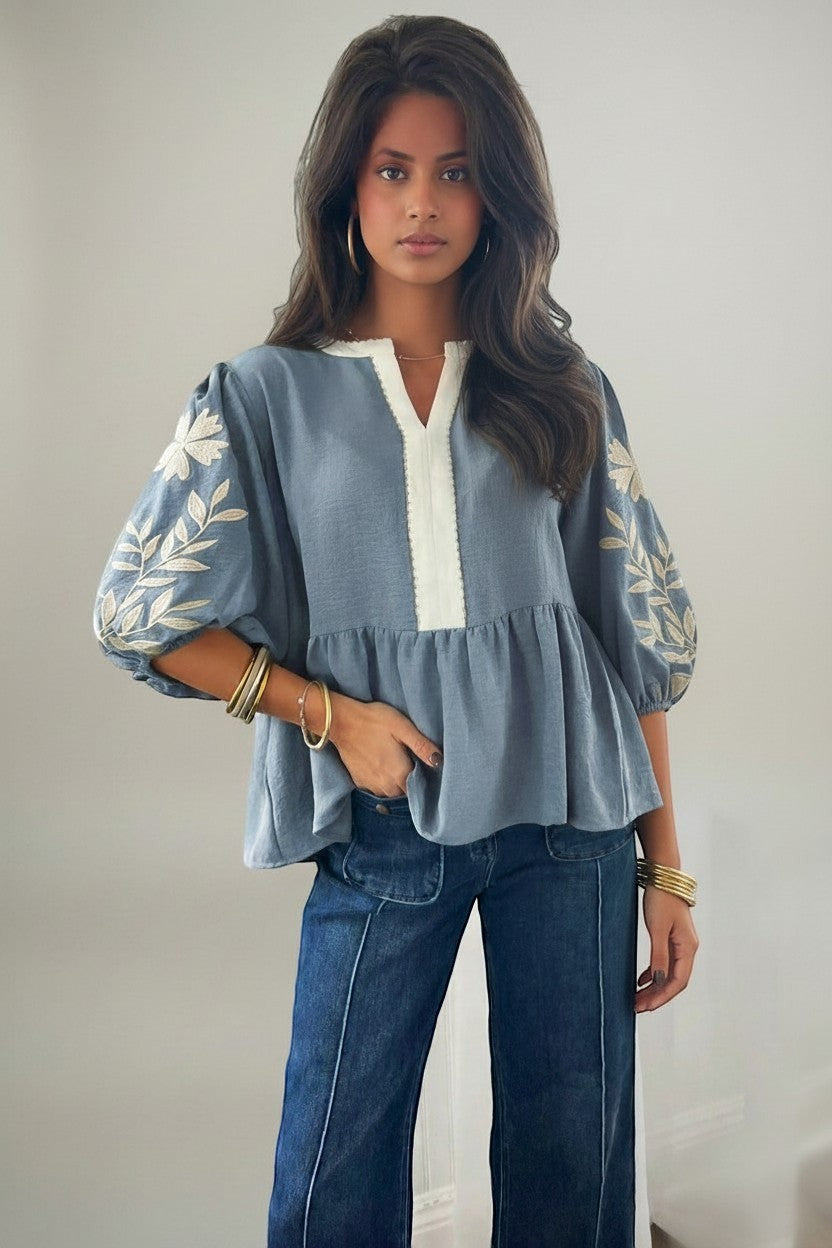 Errabelly blue babydoll blouse with V-neck, puff sleeves, and white embroidery detail on sleeves and neckline.