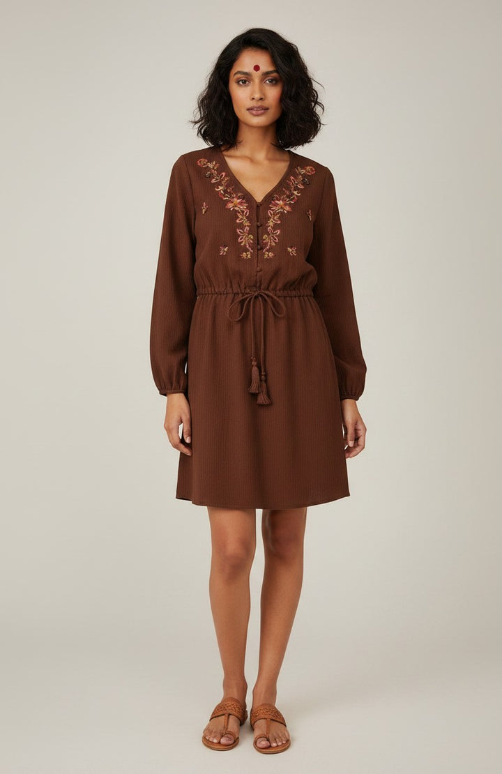 Errabelly brown long sleeve mini dress with floral embroidery on the neckline and a tassel tie waist.