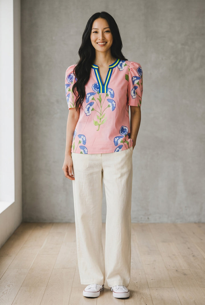Errabelly pink blouse with blue floral print, notched V-neck, and bubble sleeves. Lightweight fabric for comfortable wear.