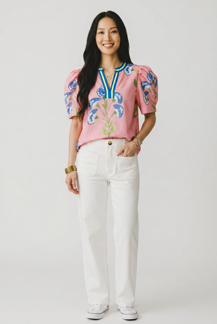 Errabelly pink blouse with blue floral print, notched V-neck with blue and yellow trim, and bubble sleeves.