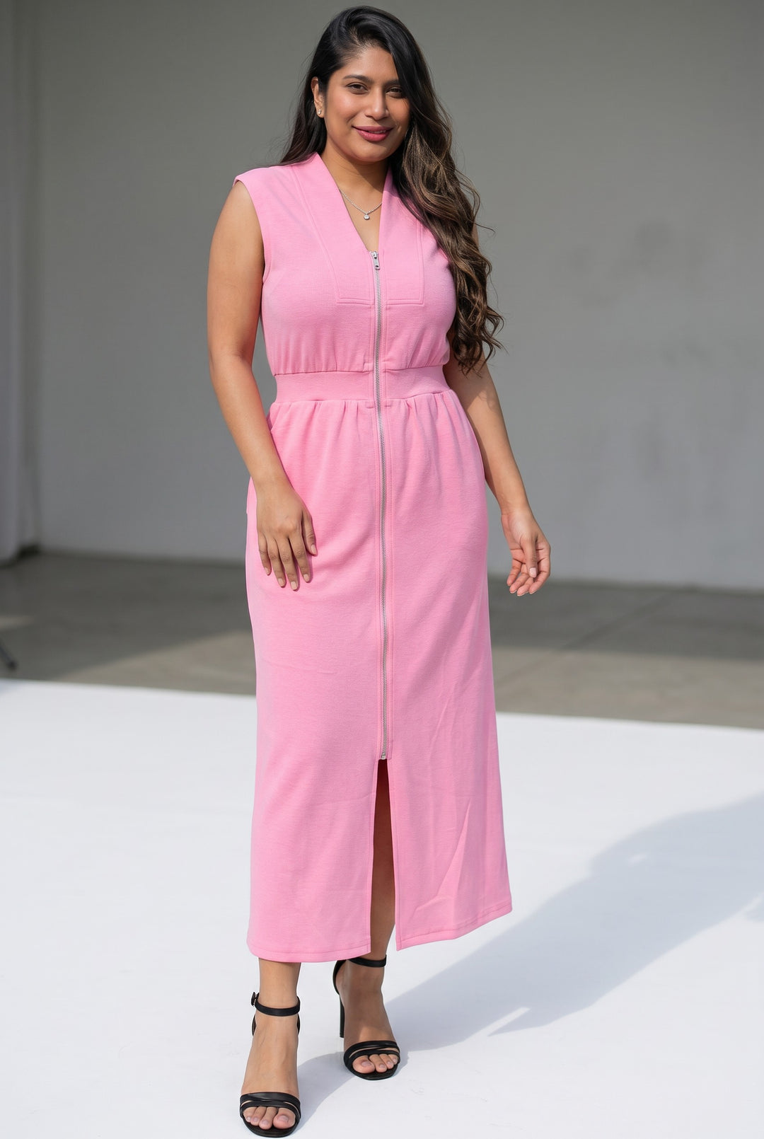 Errabelly pink sleeveless V-neck midi dress with double zip and pockets. A woman models the dress.