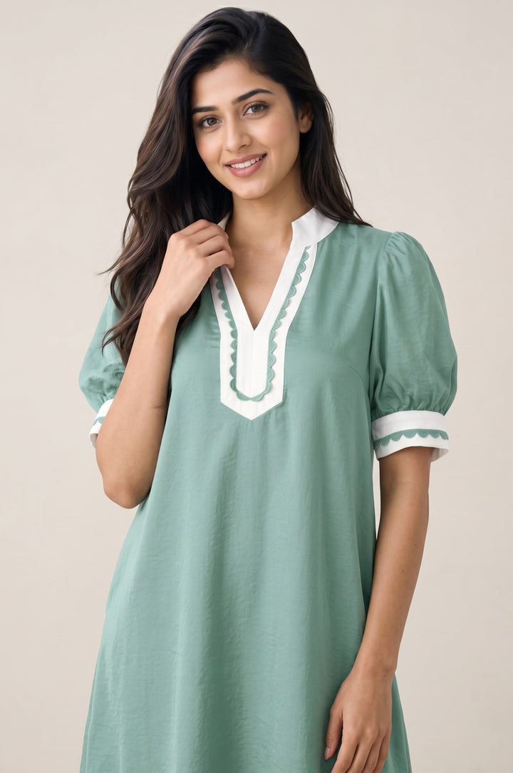 Errabelly seafoam green mini dress with white scalloped trim on the notched neckline and cuffs, featuring puff sleeves.